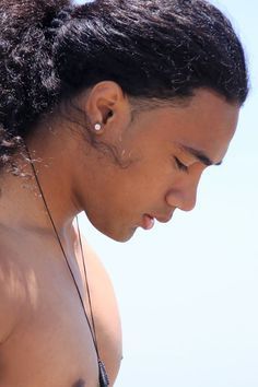 a close up of a person with no shirt on and ear phones in their ears