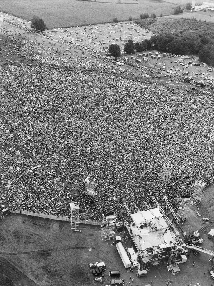 an aerial view of a large group of people gathered in the middle of a field