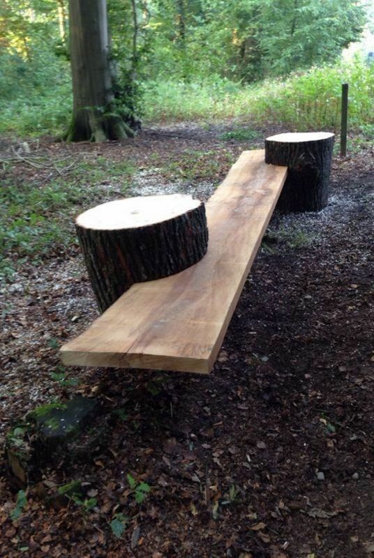 two wooden benches sitting in the middle of a forest