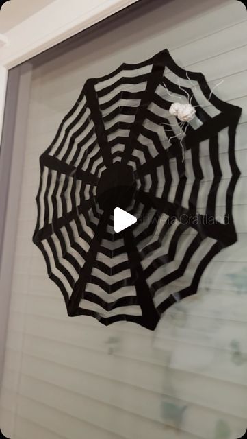 an upside down umbrella hanging from the side of a house with spider webs on it