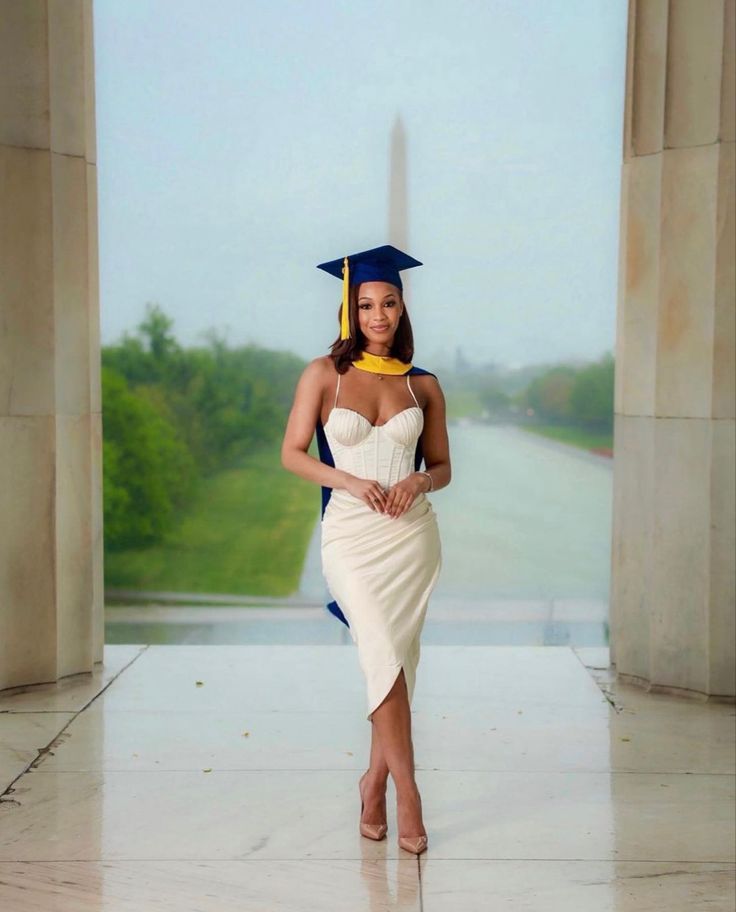 a woman in a graduation cap and gown posing for the camera with her hand on her hip