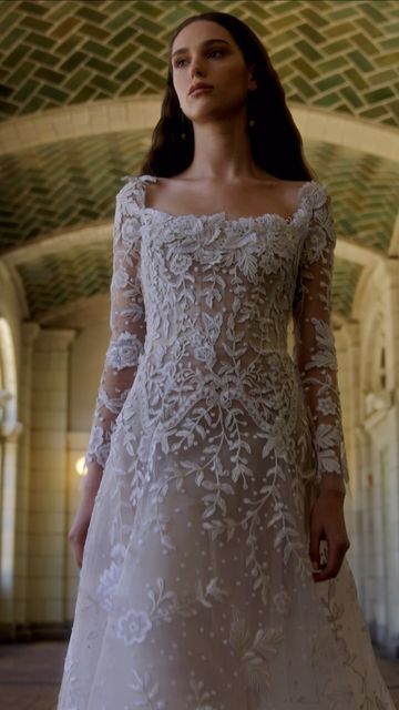 a woman in a white wedding dress standing on the floor