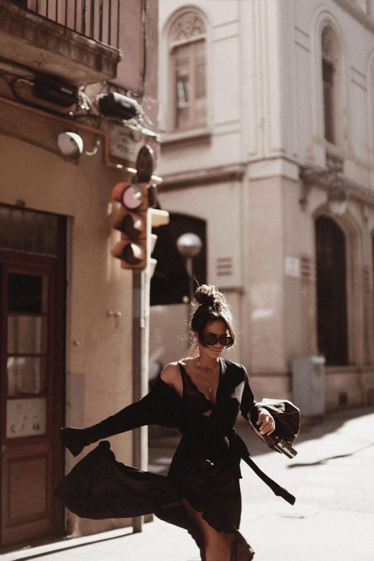 a woman is dancing on the street with her legs spread out in front of her