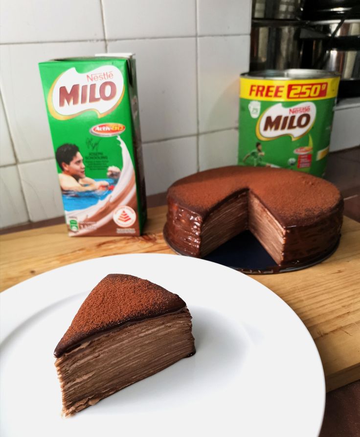 a piece of cake sitting on top of a white plate next to a box of milk