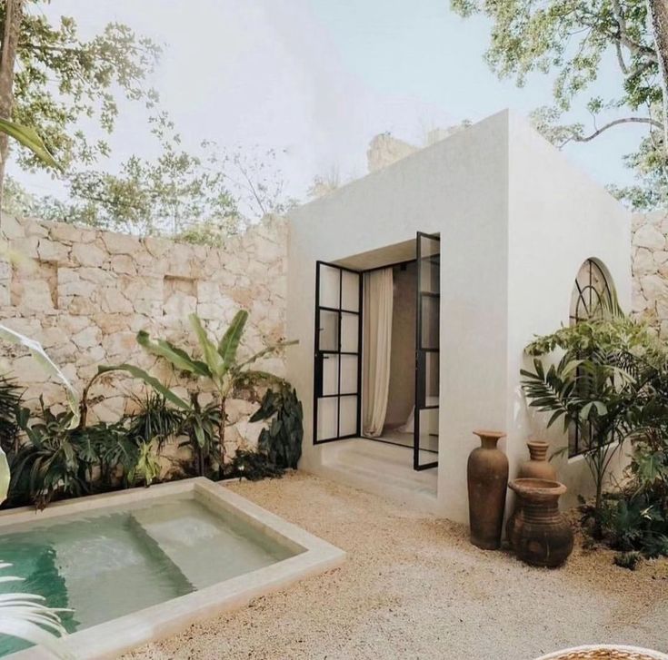 an outdoor area with a pool, potted plants and two vases