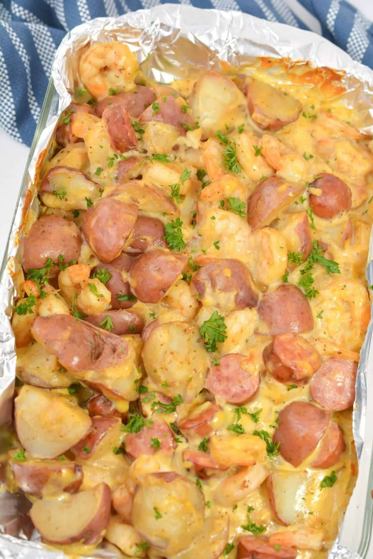 a casserole dish with sausage, potatoes and parsley