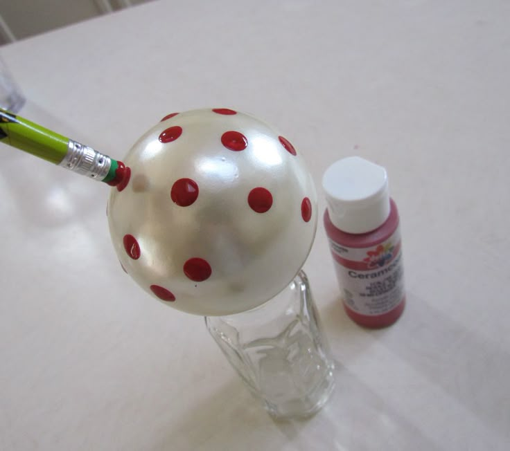 a white and red polka dot ball sitting on top of a table next to a marker