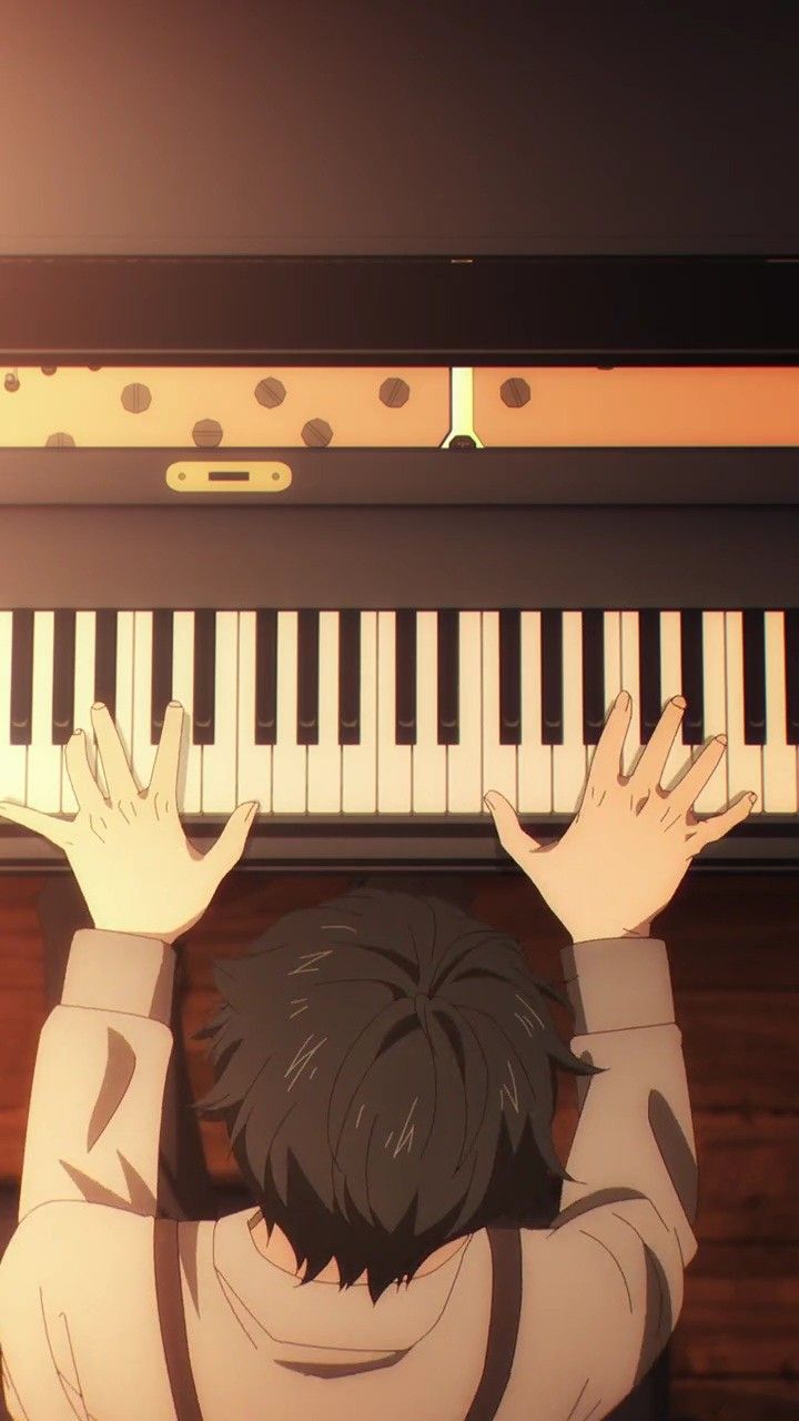 a person sitting in front of a piano with their hands up to the music keyboard