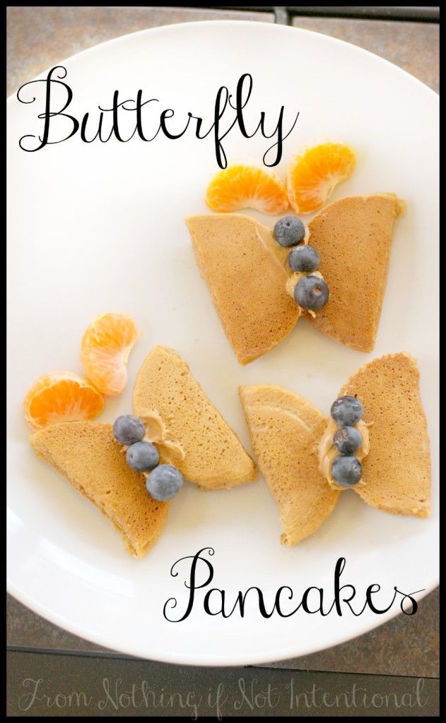 three pancakes with blueberries and oranges on top are sitting on a white plate