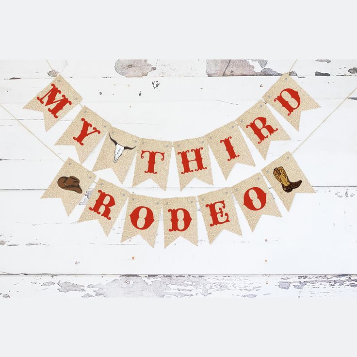 a banner that says my third rodeo is hanging on a white wooden wall with an old fashioned cowboy theme