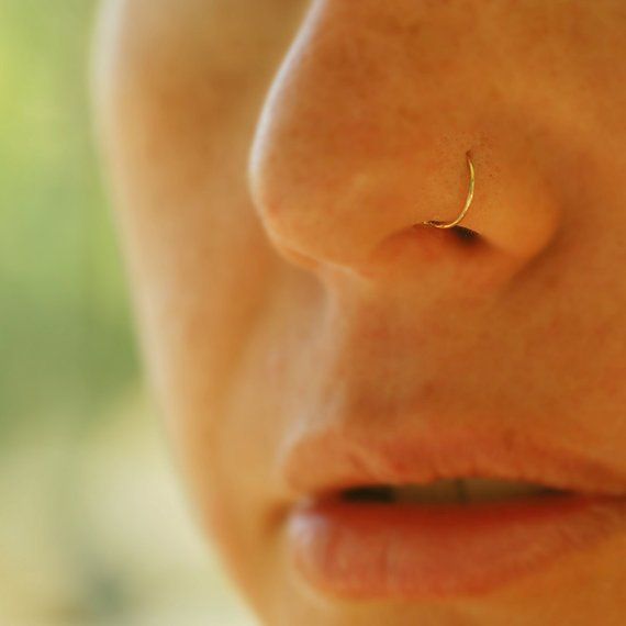 a close up of a person with a nose piercing on it's left side