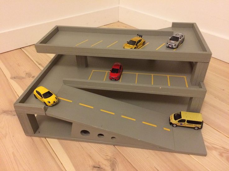 toy cars and trucks are parked on top of a play set in the shape of a car garage