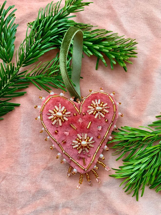 a heart shaped ornament hanging from a tree branch