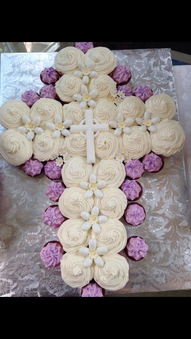 a cross made out of cupcakes sitting on top of a table