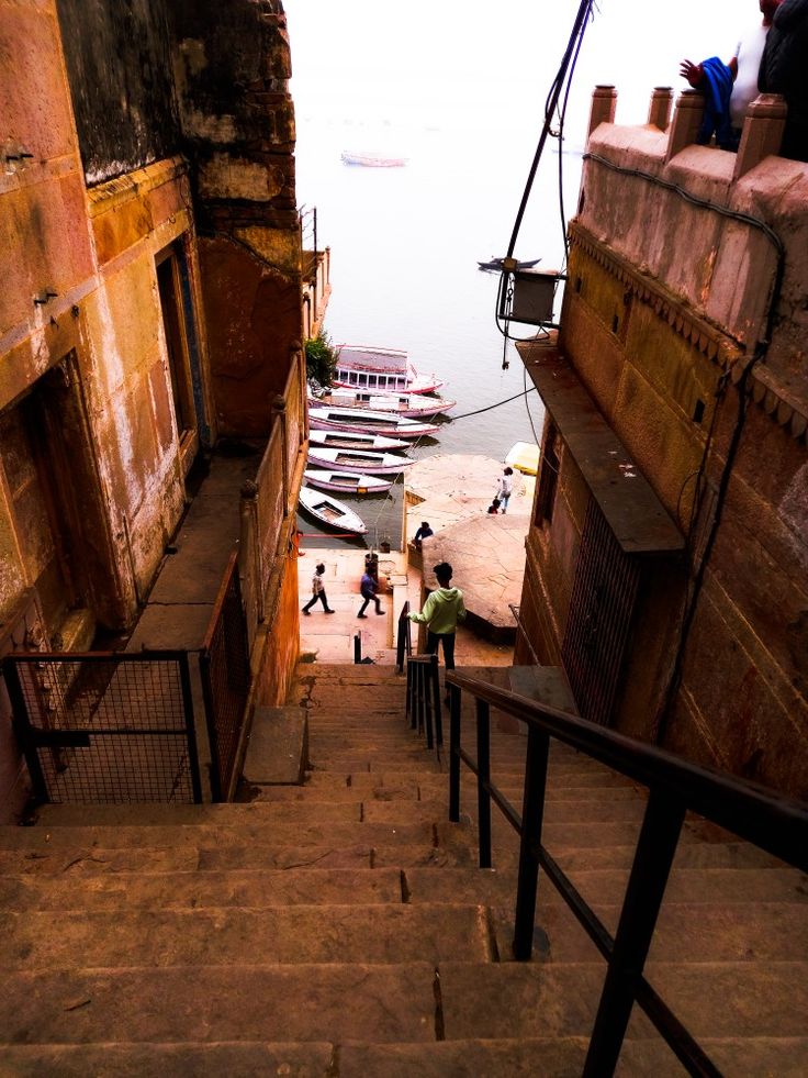 people are walking up and down the stairs in front of boats docked on the water