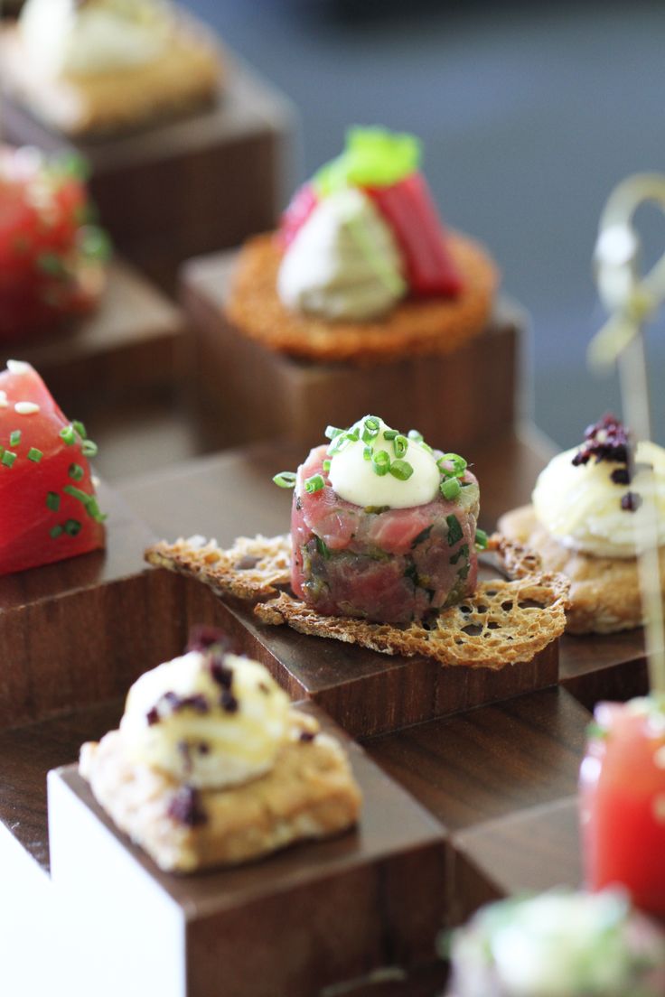 small appetizers are arranged on wooden trays