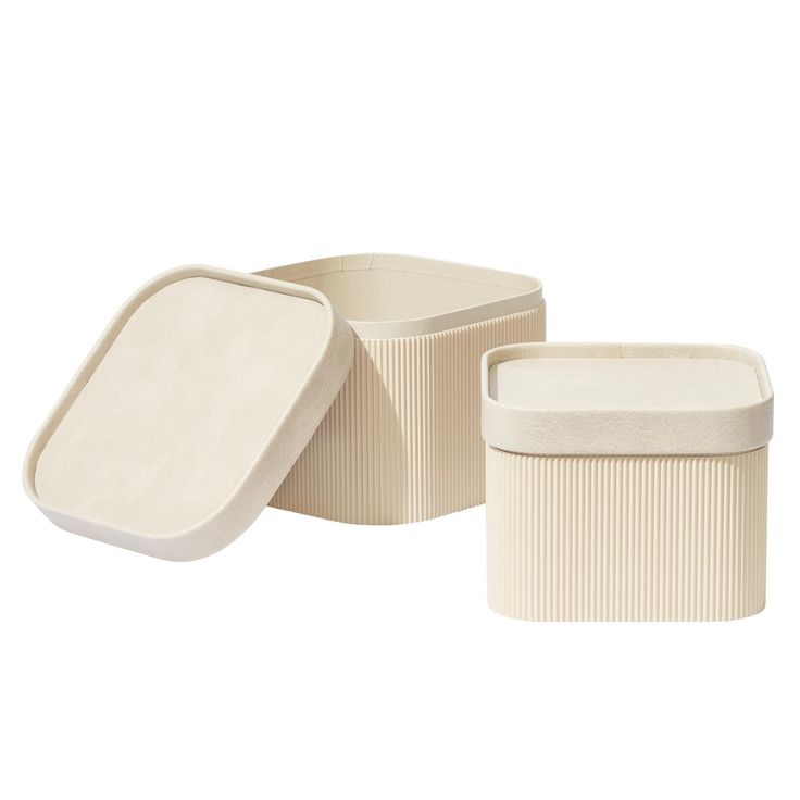 three white containers with lids are shown