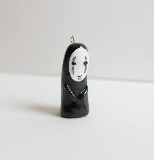 a small black and white figurine with a face painted on it's body