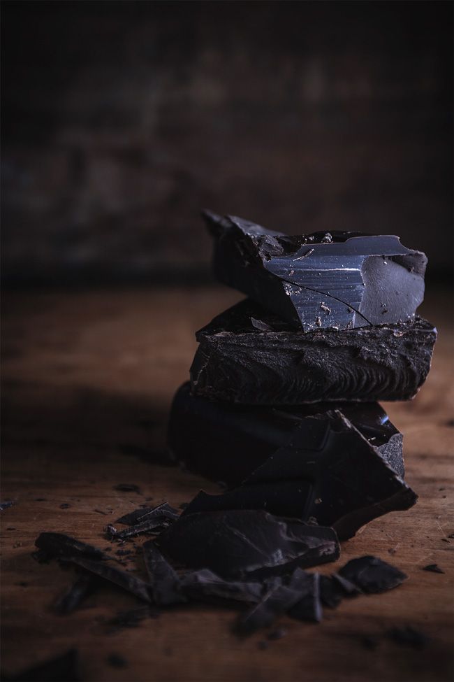 a pile of black chocolate sitting on top of a wooden table