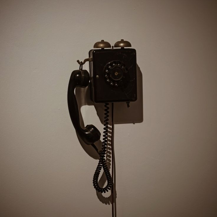 an old fashioned telephone is hanging on the wall