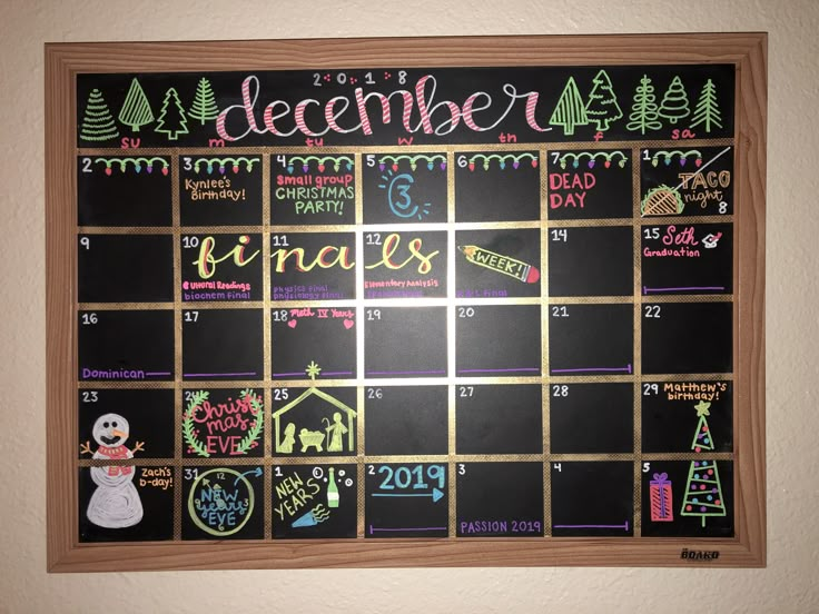 a chalkboard calendar is hanging on the wall next to a christmas tree and snowman