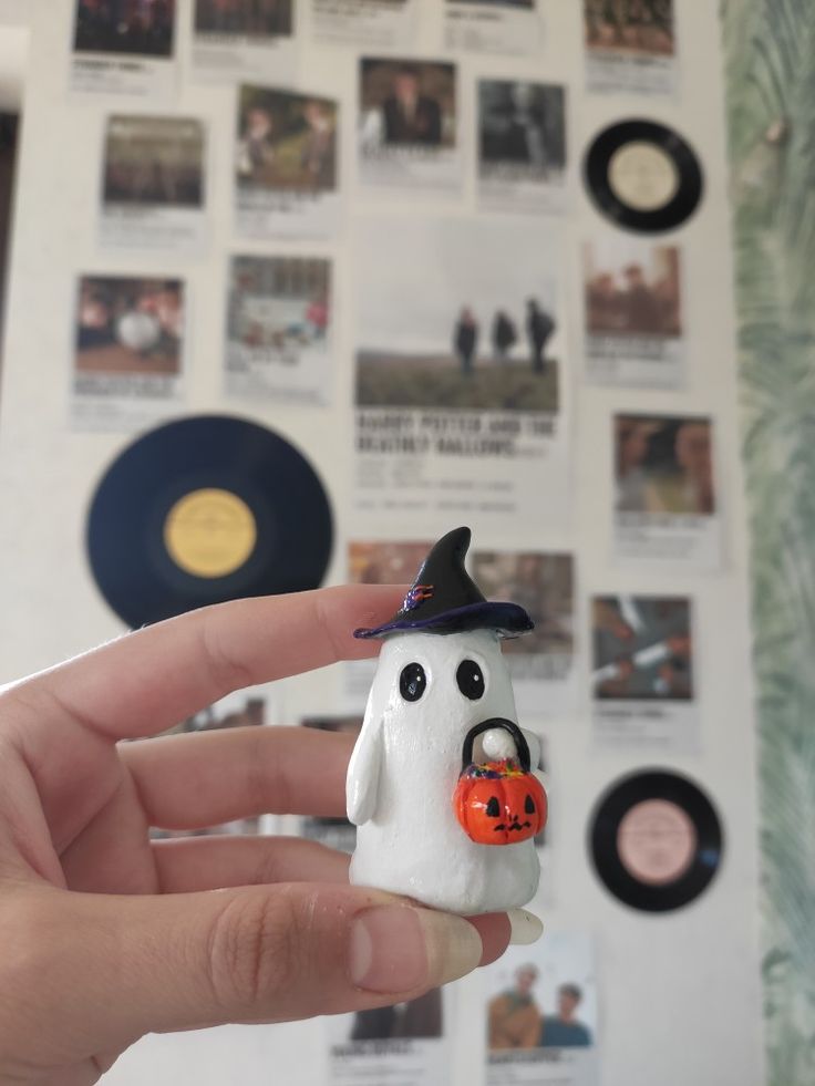 a hand holding a small toy with a halloween decoration on it