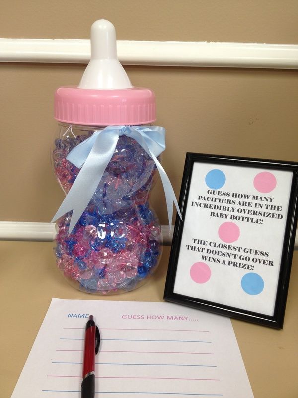 a baby bottle filled with candy next to a notepad