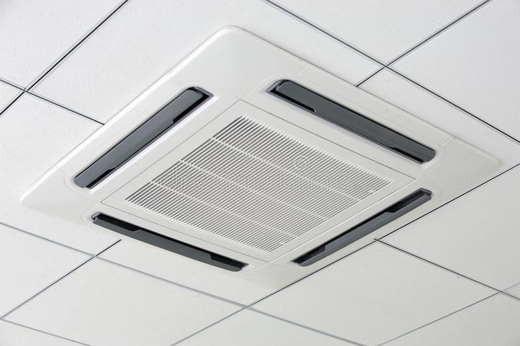 an air conditioner mounted to the ceiling in a room with white tiles on it