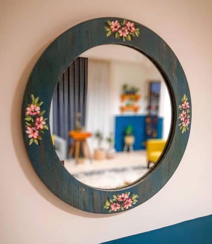 a round mirror with flowers painted on it