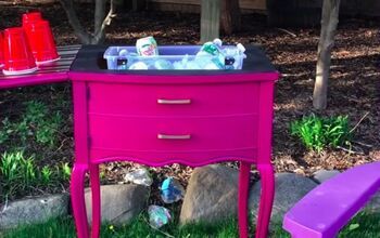 a pink table with two plastic bottles on it and a purple bench in the grass