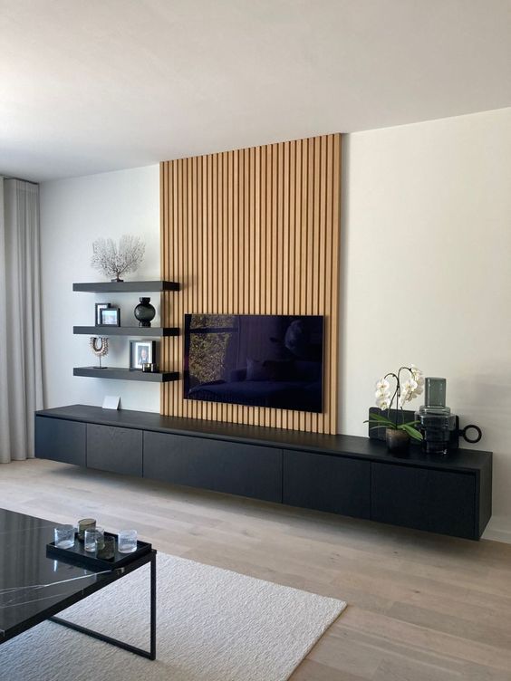 a living room with a large television on top of a wooden entertainment center next to a glass coffee table