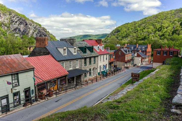 an old town with lots of buildings on the side of it and mountains in the background