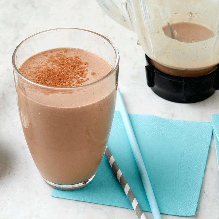 there is a glass of chocolate milkshake next to a blender