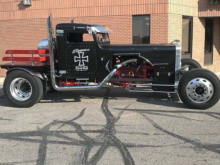 a large black truck parked in front of a brick building