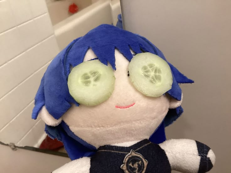 a stuffed animal with cucumbers on it's eyes sitting in front of a mirror