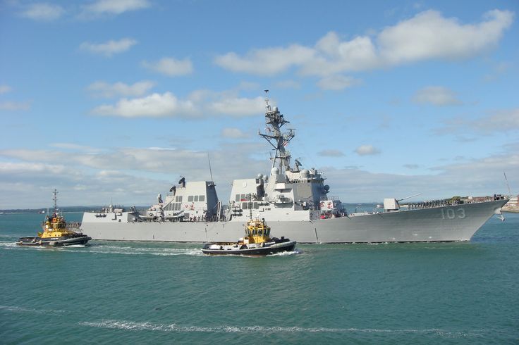 two boats in the water near a large ship