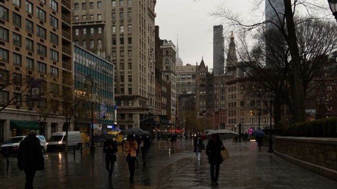 people walking down the street with umbrellas on a rainy day