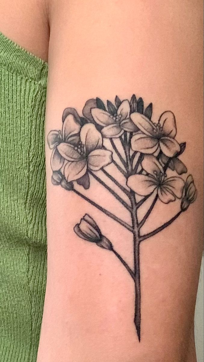 a woman's arm with a flower tattoo on it