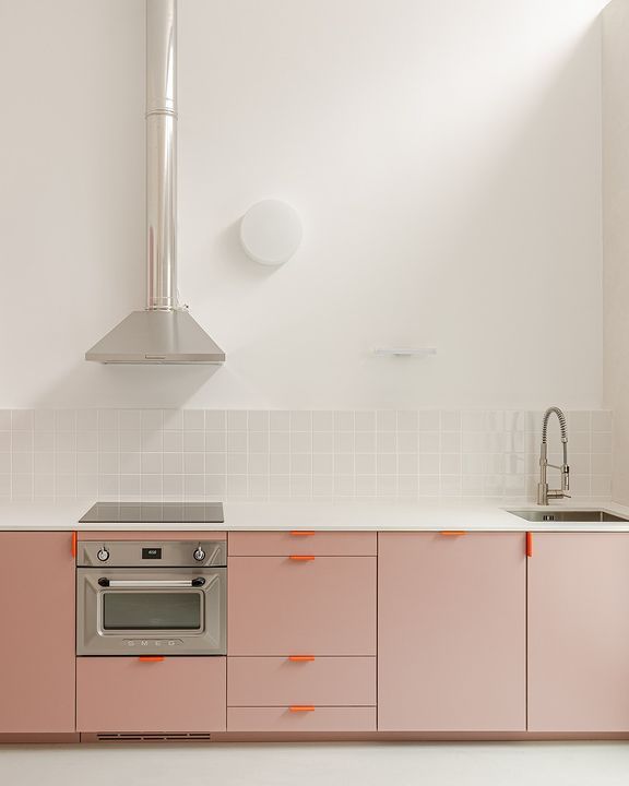 a kitchen with pink cabinets and an oven