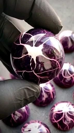 a person holding a purple ball with white designs on it