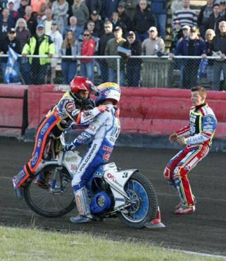 two motorcyclists are racing around the track