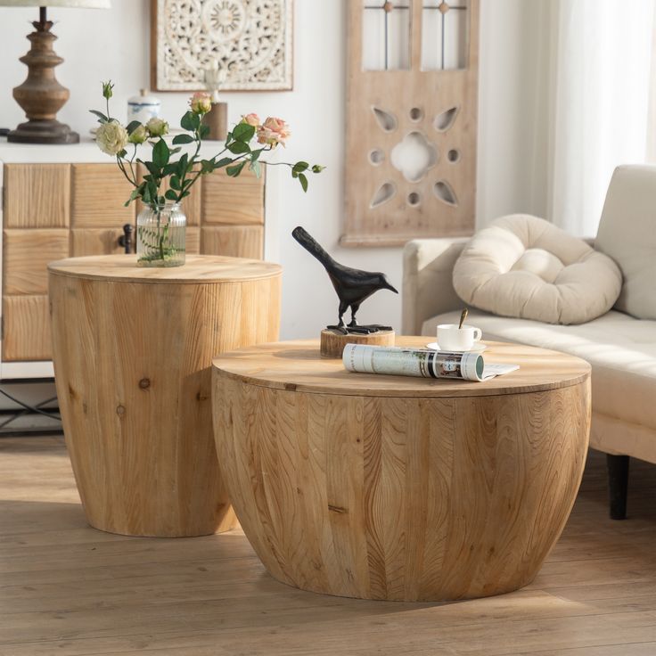 two wooden tables sitting on top of a hard wood floor next to a white couch