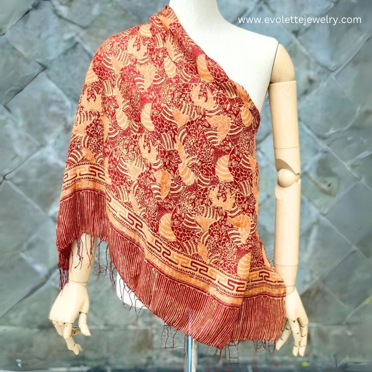 Name : Kirana Silk Scarf Fabric : 100% soft silk Size : Large (175x90 cm) Colour : Red , Gold Motif : Garden Code : SCL-DR-23Y-GD KIRANA SILK SCARF Kirana Silk Scarf is an artisan scarf (shawl) produced by La Maison D'Evolette - Elvinna Brion. it is a genuine silk fabric, displaying Batik pattern that preserve the rich cultural and multi-faceted heritage of Indonesia.  The technic we use is combining between "Batik Tulis" (Handwritten/ Handdrawn Batik) and "Batik Tjap" (Stamped Batik). Silk Silk is a natural fiber produced by silkworms. It is made from the cocoons spun by the larvae of the silk moth, known scientifically as "Bombyx mori". The silk production process begins with the cultivation of silkworms and ends with the extraction of silk threads from the cocoons. The result of silk fa Silk Scarves With Traditional Patterns, Silk Scarves With Traditional Patterns And Drape, Silk Shawl Scarves For Beach, Silk Shawl Scarf For The Beach, Silk Shawl Scarf For Beach, Patterned Silk Scarf Shawl, Bohemian Silk Scarf With Batik Print, Patterned Silk Shawl Scarf, Traditional Handmade Silk Scarves