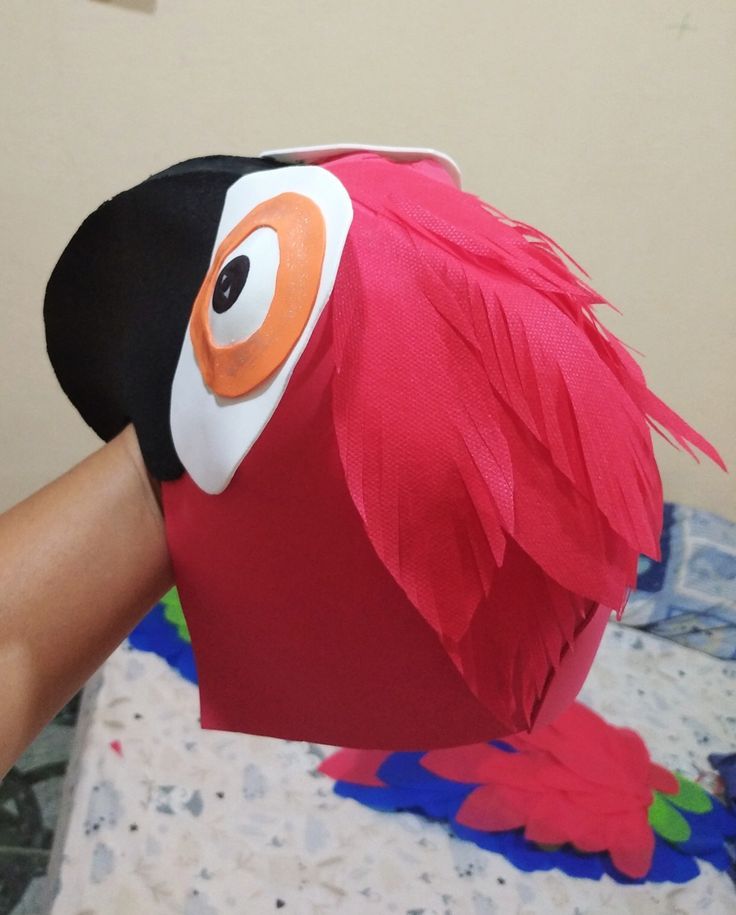 a person is making a paper mache bird head out of construction material with scissors