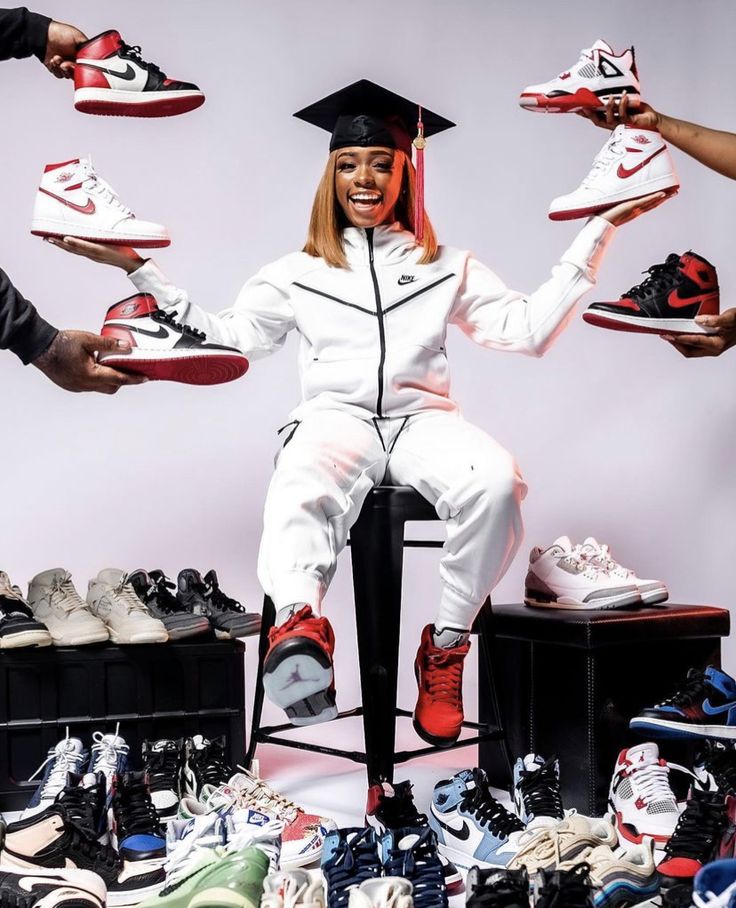 a woman sitting on top of a chair surrounded by shoes and sneakers in front of her