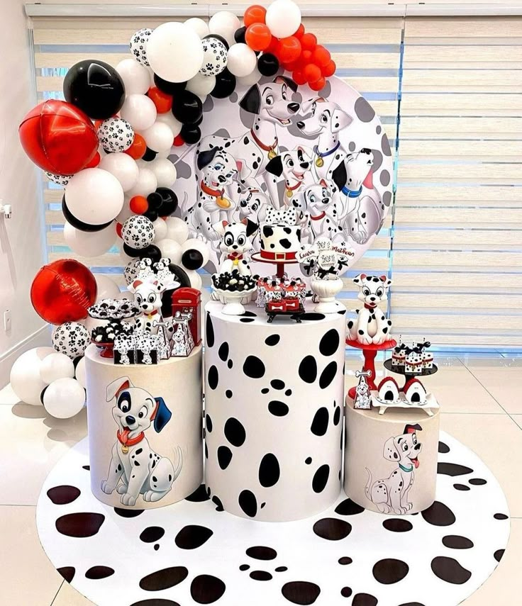 a table topped with lots of balloons and dalmatian themed decorations on top of it