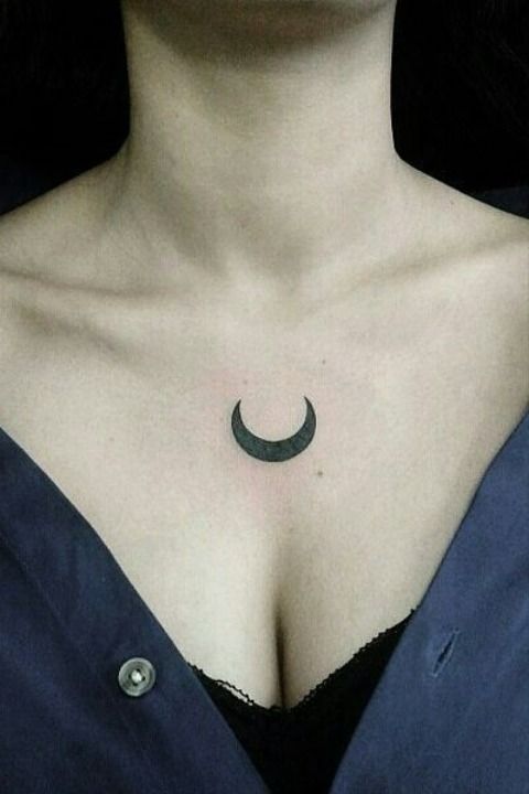 a woman's chest with a crescent tattoo on her left breast and the moon in the middle