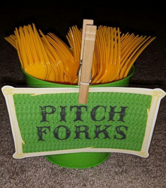 a green bucket with yellow forks in it and a sign that says pitch fork's