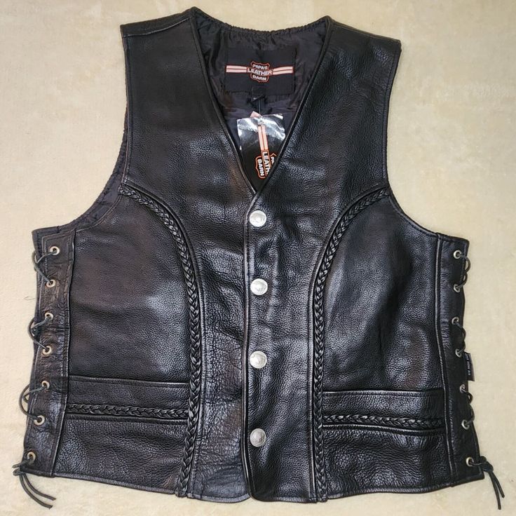 This black leather vest from Papa is perfect for any biker or motorcycle enthusiast. With a braided design and button accents, it's a stylish addition to any wardrobe. The vest features a snap closure, making it easy to put on and take off. The XL size and regular fit make it comfortable for any occasion, whether it's casual wear or workwear. It's also great for travel, with plenty of pockets for storage. The vest is made of high-quality leather and is built for performance, whether you're riding or walking. Add this vest to your collection and ride in style! Please See Photos For Description and Measurments We Appreciate You Looking! Black Leather Vest, Vests Mens, Leather Vest, High Quality Leather, Vest Jacket, Casual Wear, Work Wear, Black Leather, Mens Accessories