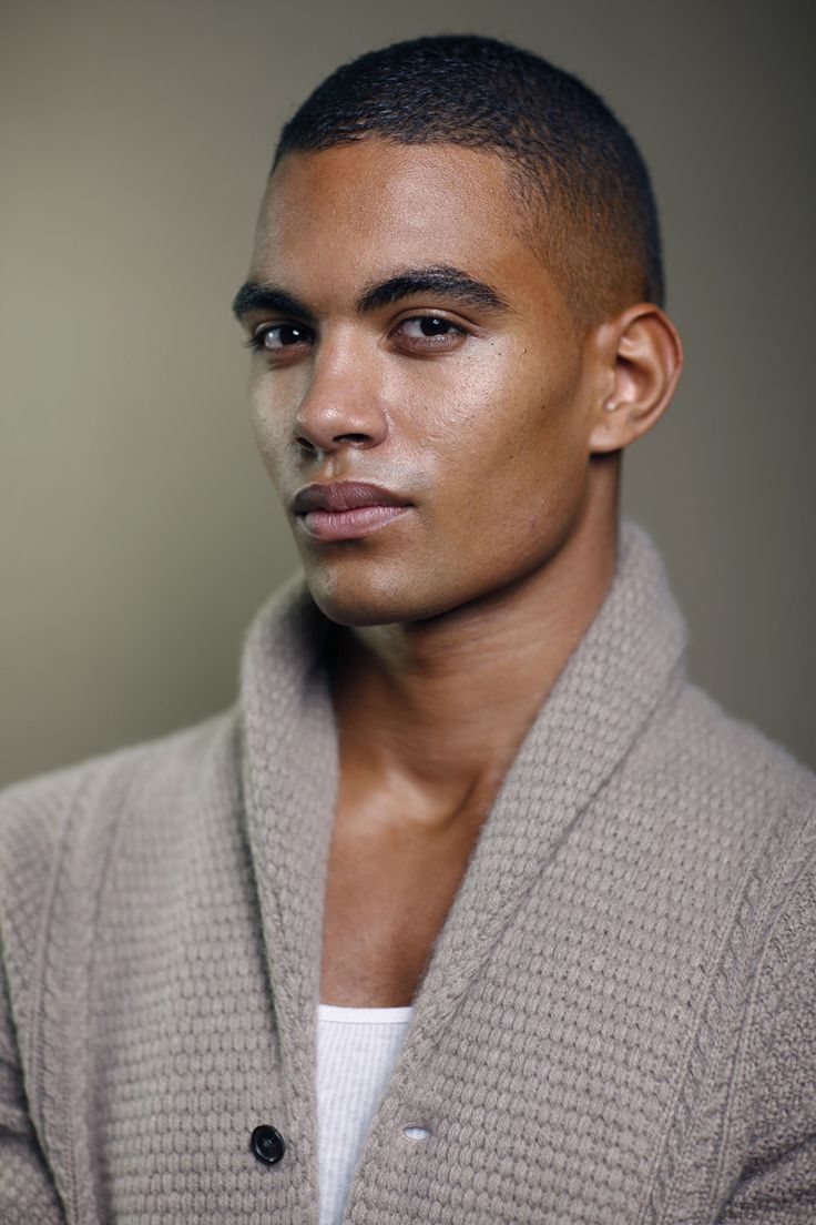 a man in a cardigan looking at the camera